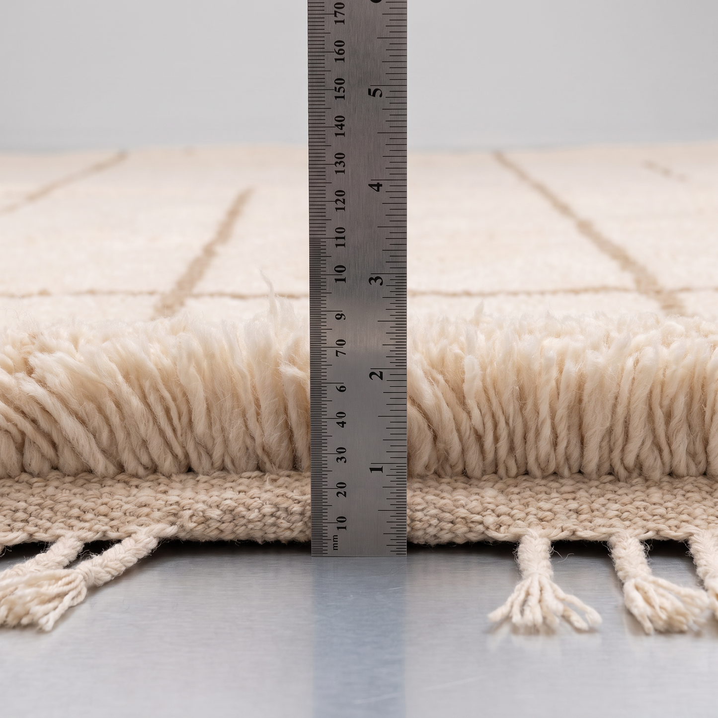 Mosatar - Mesure de l'épaisseur du tapis Berbère avec une règle graduée