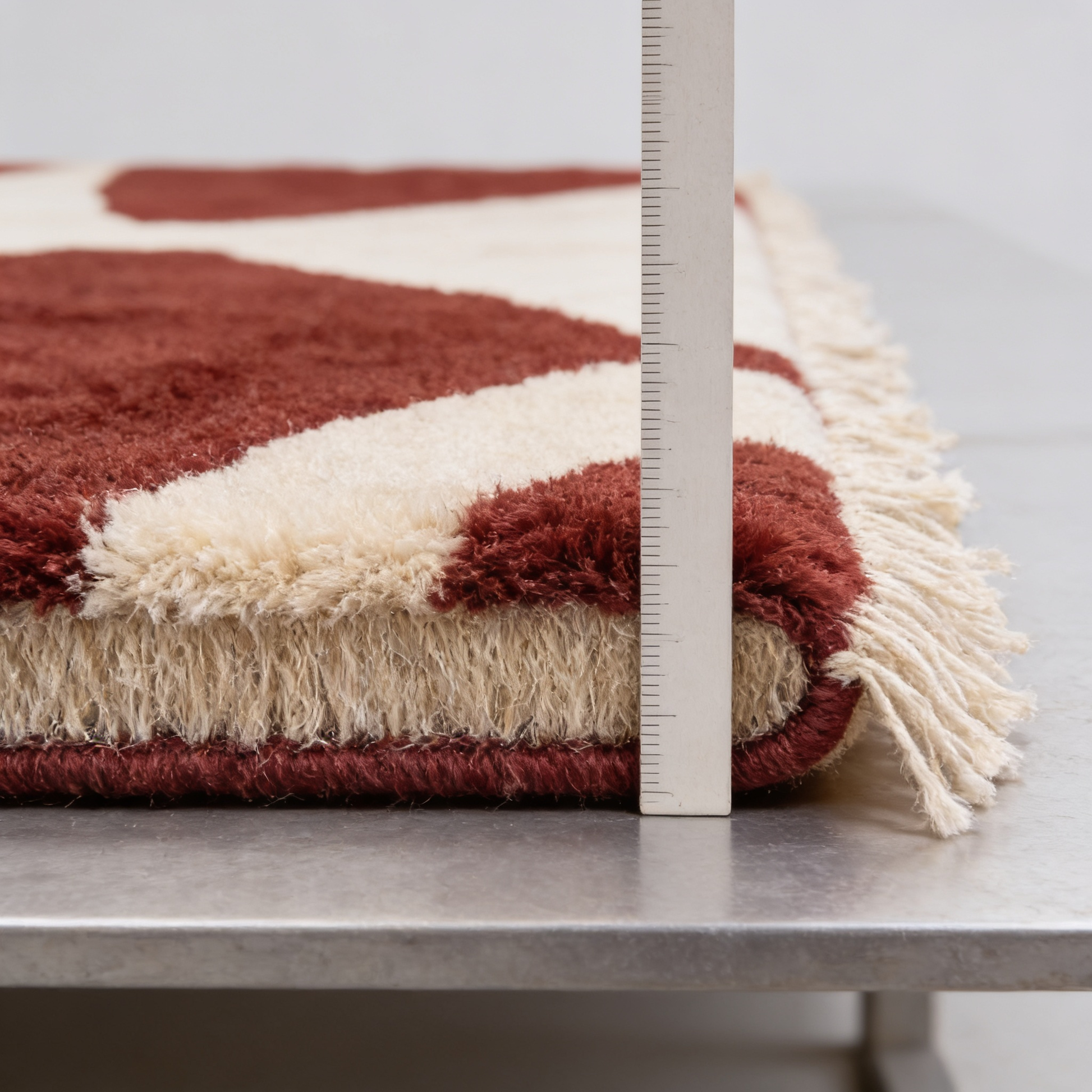 Tapis Berbère Beni Ouarain rouge intense - mesure de l'épaisseur avec une règle graduée