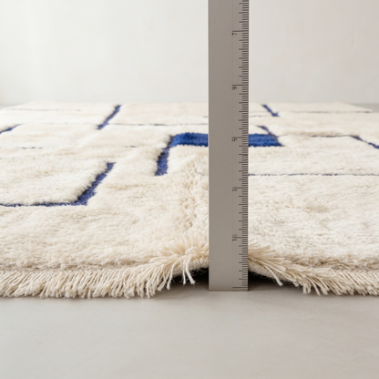 Tapis Berbère Mrirt écru à motifs bleus - mesure de l'épaisseur avec une règle graduée