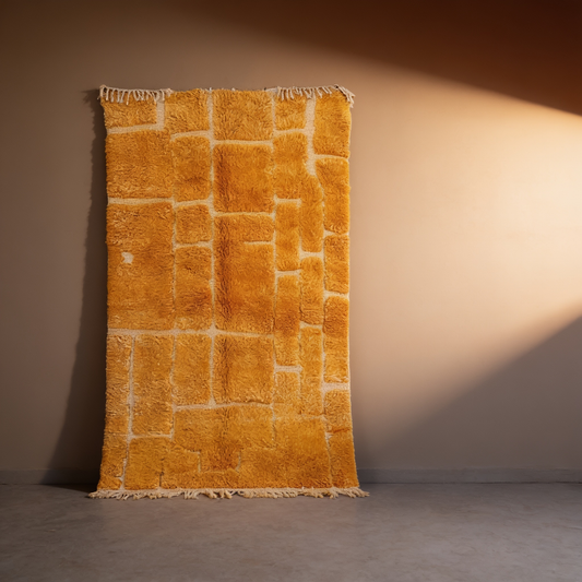 Tapis Berbère Mrirt coloré jaune d'or à losanges, vue de face sur fond gris studio